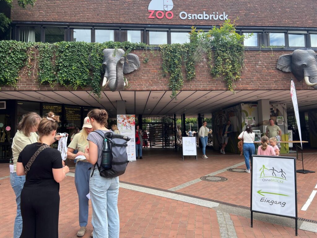 Zootag der Osnabrücke. Personen, die vorm Zoo Osnabrück stehen